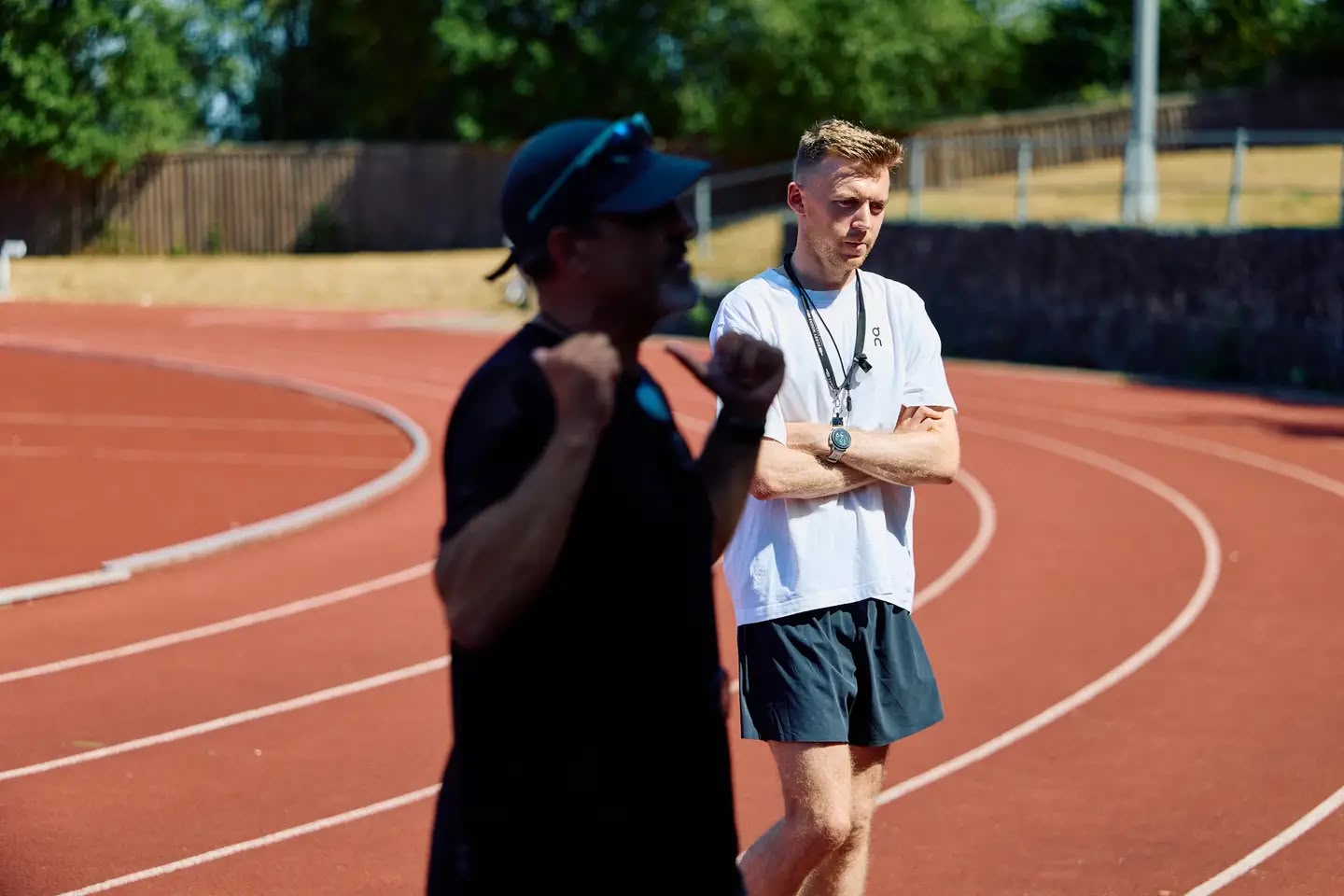 Neil observing an athlete closely during a track session
